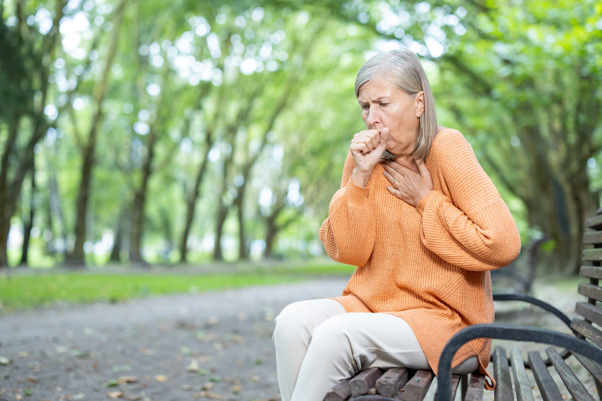 Senior Woman Coughing While Walking Trail